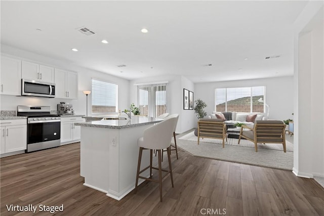 kitchen featuring open floor plan, visible vents, stainless steel appliances, and a healthy amount of sunlight