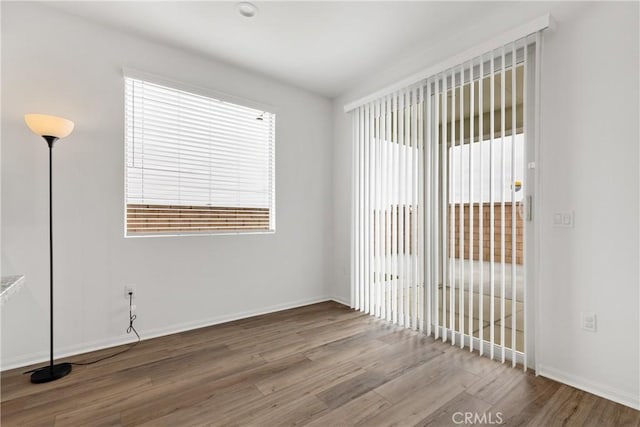 unfurnished room featuring baseboards and wood finished floors