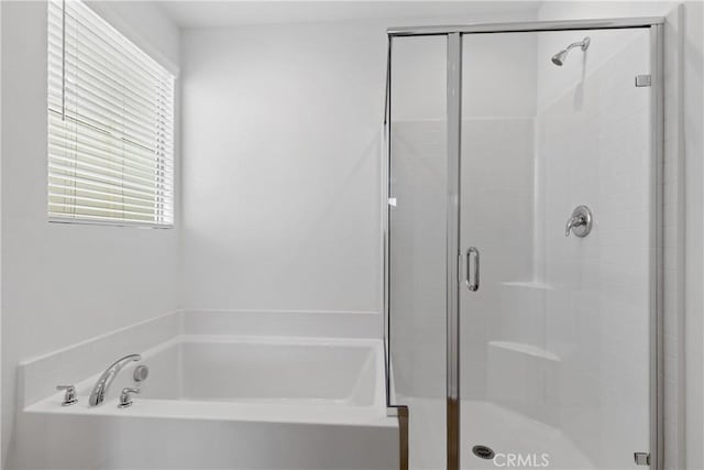 full bath featuring a shower stall and a garden tub