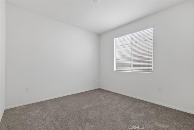spare room with carpet flooring and baseboards