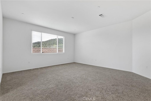empty room featuring visible vents, carpet, and baseboards