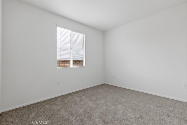 unfurnished room with baseboards and carpet floors