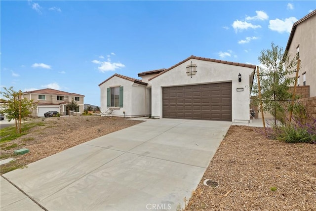 mediterranean / spanish-style home with a tile roof, a garage, driveway, stucco siding, and fence