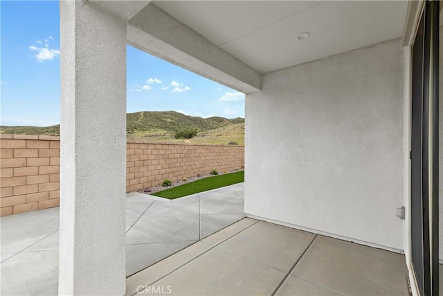 view of patio with a mountain view and a fenced backyard