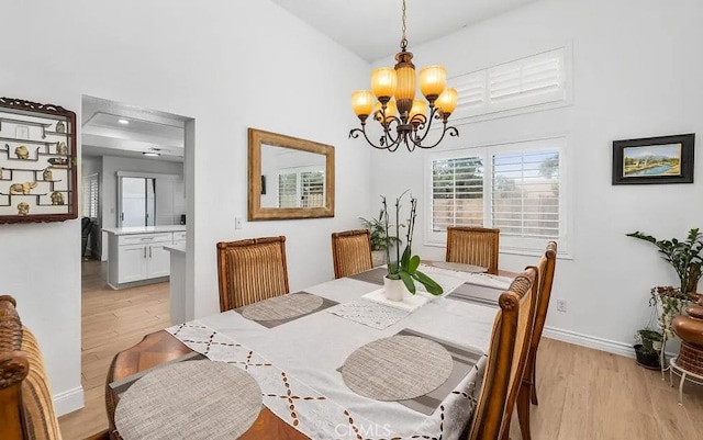 39675 Via Las Palmas, Murrieta, CA 92563 - dining space featuring baseboards, a high ceiling, light wood-style flooring, and a chandelier