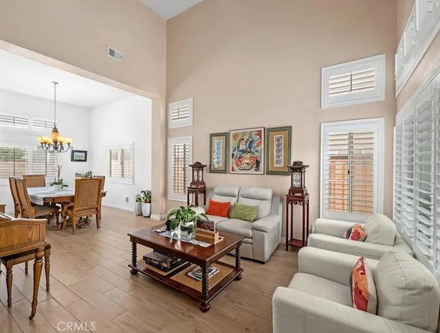 39675 Via Las Palmas, Murrieta, CA 92563 - living room with an inviting chandelier, baseboards, a high ceiling, and light wood-type flooring