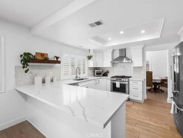 39675 Via Las Palmas, Murrieta, CA 92563 - kitchen with wall chimney range hood, visible vents, a sink, a peninsula, and stainless steel appliances