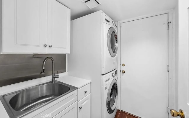 39675 Via Las Palmas, Murrieta, CA 92563 - clothes washing area featuring visible vents, wood finished floors, cabinet space, stacked washing maching and dryer, and a sink