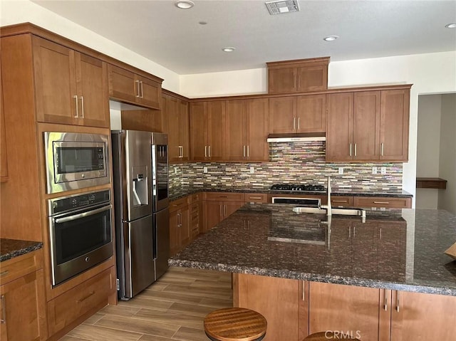 164 Newall, Irvine, CA 92618 - kitchen featuring stainless steel appliances, tasteful backsplash, light wood finished floors, under cabinet range hood, and recessed lighting