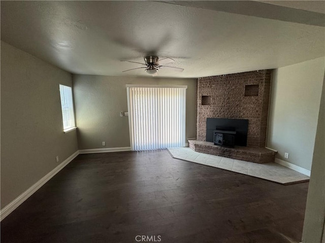 3723 Buckeye St, Clearlake, CA 95422 - unfurnished living room featuring baseboards, a ceiling fan, a wood stove, and wood finished floors
