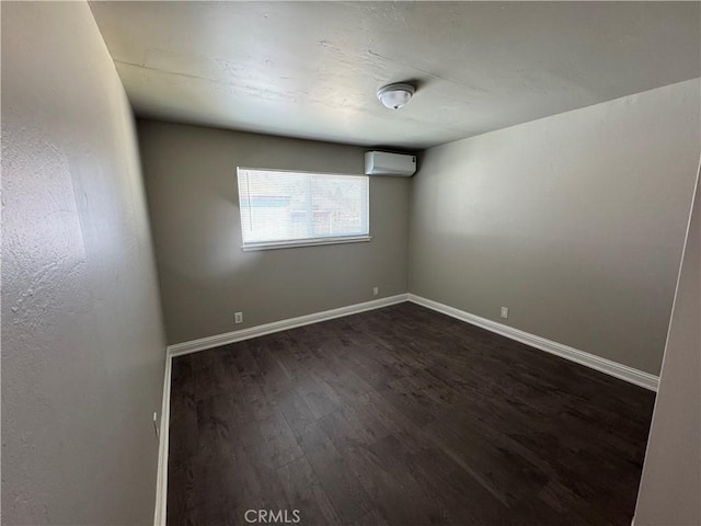 3723 Buckeye St, Clearlake, CA 95422 - spare room featuring baseboards, a wall unit AC, and dark wood finished floors