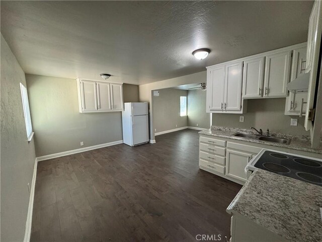 3723 Buckeye St, Clearlake, CA 95422 - kitchen with white cabinets, a sink, dark wood-type flooring, freestanding refrigerator, and baseboards