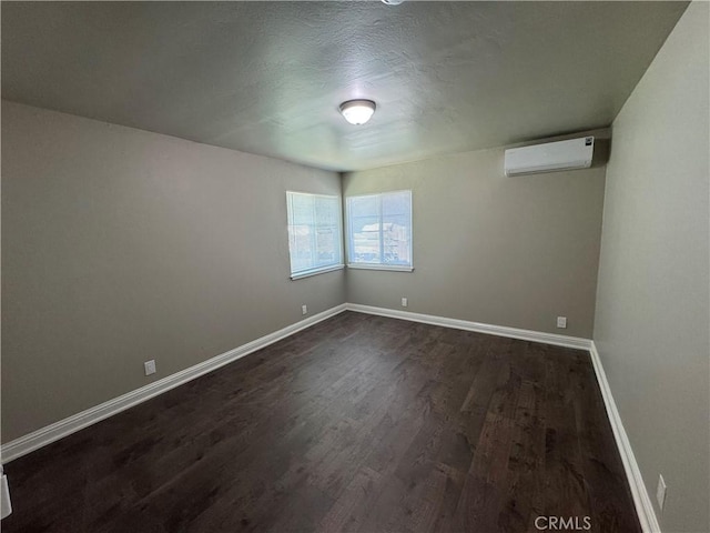 3723 Buckeye St, Clearlake, CA 95422 - spare room featuring dark wood-type flooring, a wall mounted air conditioner, and baseboards