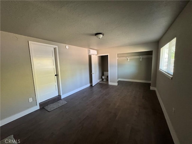 3723 Buckeye St, Clearlake, CA 95422 - unfurnished bedroom featuring baseboards, dark wood-style floors, a textured ceiling, and a wall mounted air conditioner