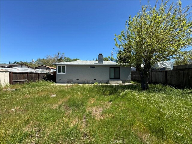 3723 Buckeye St, Clearlake, CA 95422 - back of property with entry steps, a chimney, a fenced backyard, and crawl space
