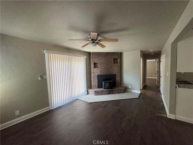 3723 Buckeye St, Clearlake, CA 95422 - unfurnished living room with baseboards, a ceiling fan, wood finished floors, and a wood stove