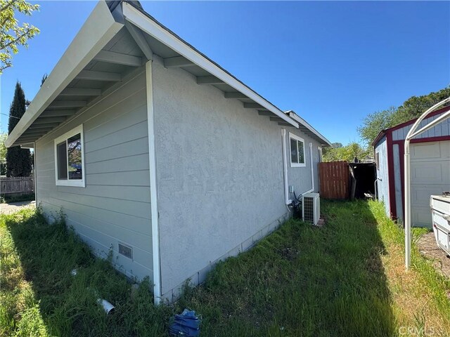 3723 Buckeye St, Clearlake, CA 95422 - view of home's exterior with stucco siding, fence, and central AC