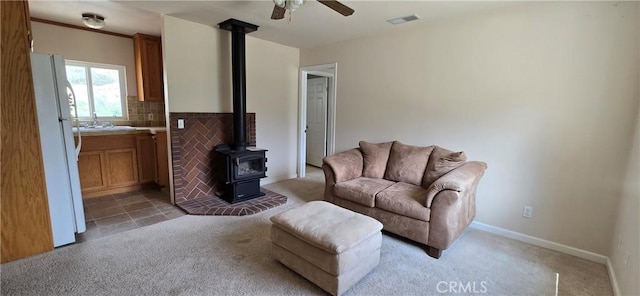1929 Lebec Oaks Dr, Lebec, CA 93243 - living area with a wood stove, a ceiling fan, light carpet, and visible vents