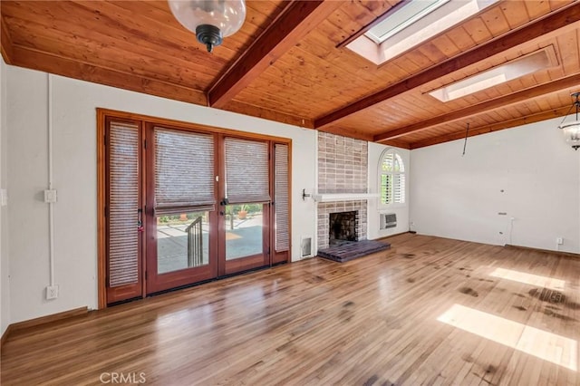 1341 E Harvest Moon St, West Covina, CA 91792 - unfurnished living room featuring wooden ceiling with exposed beams, a skylight, wood finished floors, french doors, and a brick fireplace