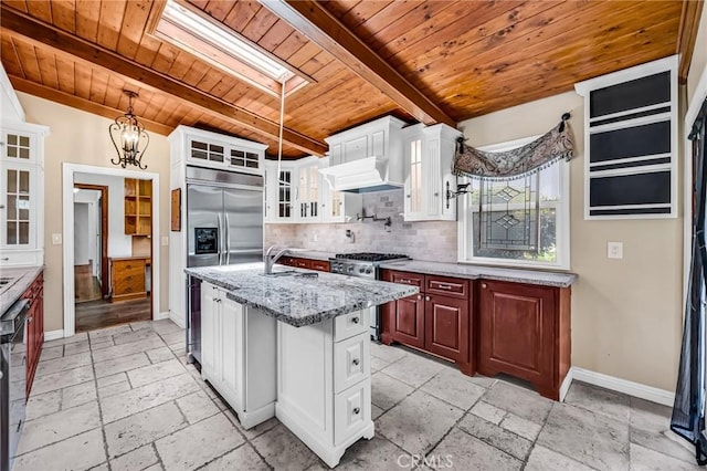 1341 E Harvest Moon St, West Covina, CA 91792 - kitchen featuring wood ceiling with exposed beams, appliances with stainless steel finishes, stone tile flooring, a skylight, and backsplash