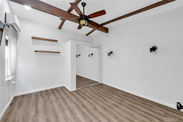 1341 E Harvest Moon St, West Covina, CA 91792 - unfurnished bedroom with a wall unit AC, wood finished floors, baseboards, a closet, and ceiling fan