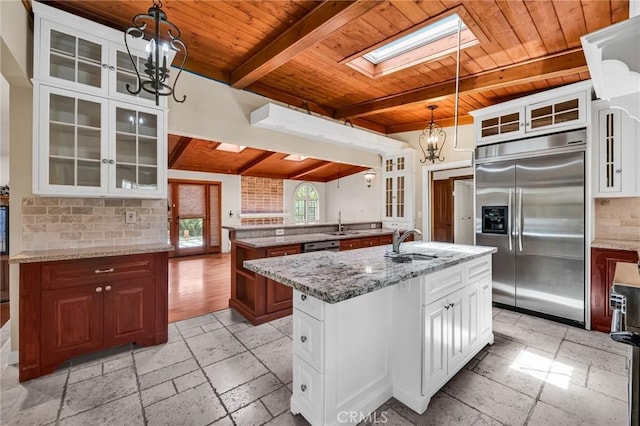 1341 E Harvest Moon St, West Covina, CA 91792 - kitchen with stainless steel built in refrigerator, wood ceiling with exposed beams, a chandelier, a skylight, and an island with sink