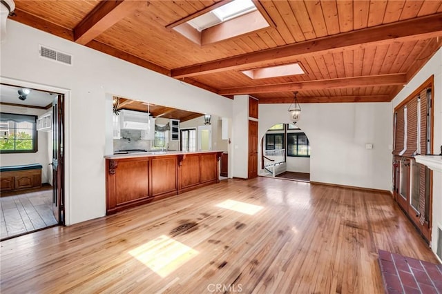 1341 E Harvest Moon St, West Covina, CA 91792 - unfurnished living room with a skylight, wood ceiling with exposed beams, light wood finished floors, plenty of natural light, and baseboards