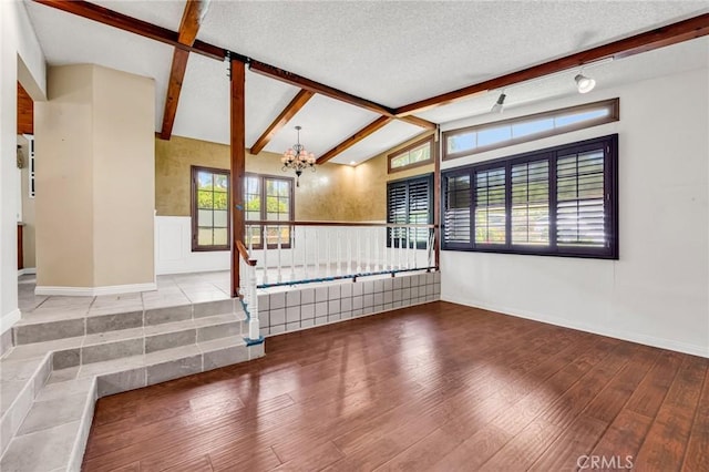 1341 E Harvest Moon St, West Covina, CA 91792 - unfurnished living room with wood finished floors, a wainscoted wall, a chandelier, baseboards, and a textured ceiling