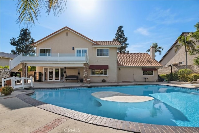 view of swimming pool with a patio area, french doors, fence, a diving board, and a fenced in pool