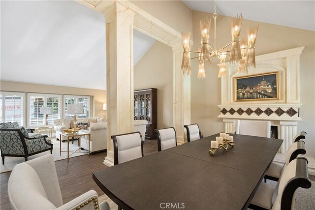 dining area with decorative columns, wood finished floors, high vaulted ceiling, and a chandelier