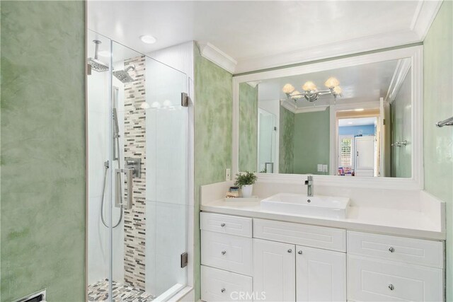 bathroom featuring vanity, a stall shower, ornamental molding, and an inviting chandelier