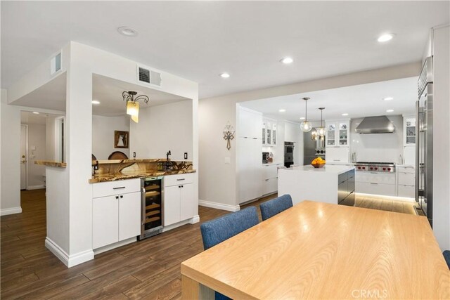 11030 Cozycroft Ave, Chatsworth, CA 91311 - kitchen featuring beverage cooler, wall chimney exhaust hood, a kitchen island, dark wood-style floors, and baseboards
