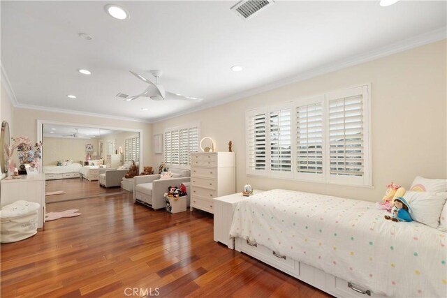 bedroom with recessed lighting, wood finished floors, visible vents, and crown molding