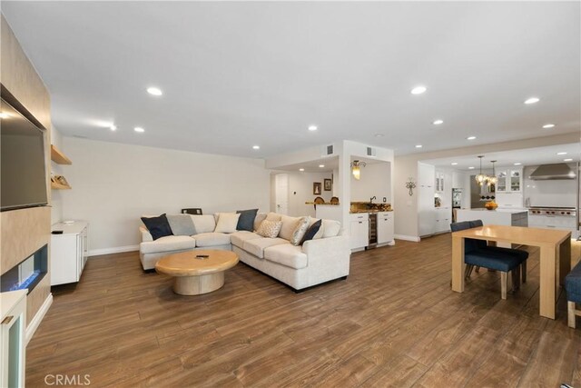 living area featuring visible vents, baseboards, recessed lighting, and dark wood finished floors