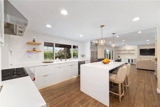 kitchen featuring a center island, extractor fan, white cabinetry, modern cabinets, and appliances with stainless steel finishes