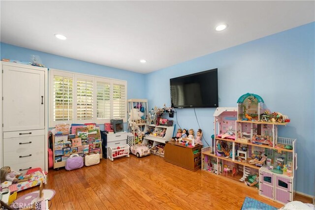 recreation room with wood finished floors and recessed lighting