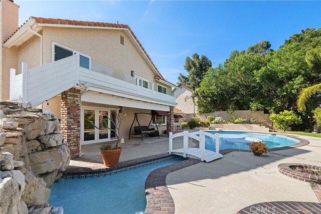 back of house featuring a fenced in pool, fence, stucco siding, a patio area, and french doors