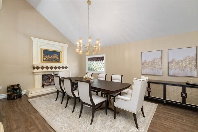 dining room featuring vaulted ceiling, wood finished floors, and a chandelier