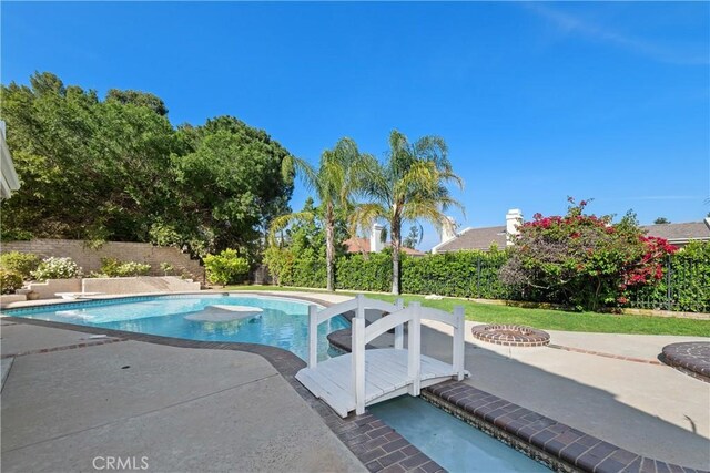 view of swimming pool with a fenced backyard, a fenced in pool, a patio, and an outdoor fire pit