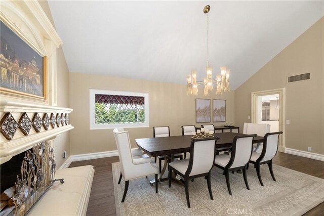 dining space with baseboards, visible vents, a notable chandelier, wood finished floors, and high vaulted ceiling