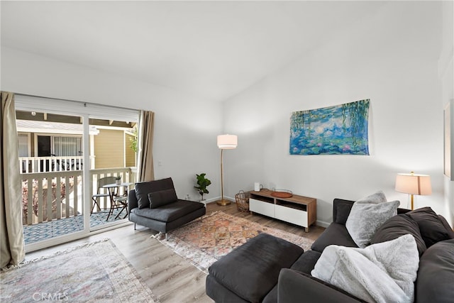 living room with baseboards, vaulted ceiling, and wood finished floors