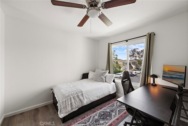 bedroom featuring baseboards, a ceiling fan, and wood finished floors