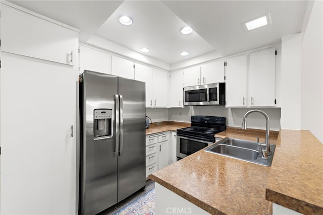 kitchen with recessed lighting, a sink, white cabinets, and stainless steel appliances