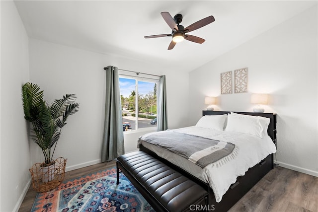 bedroom featuring baseboards, ceiling fan, wood finished floors, and lofted ceiling