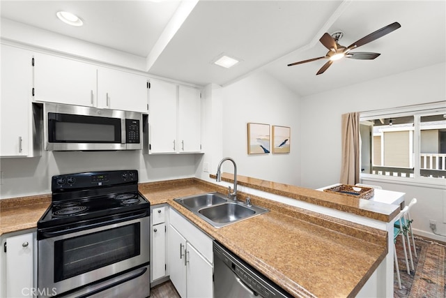 kitchen featuring a sink, appliances with stainless steel finishes, a peninsula, and white cabinetry