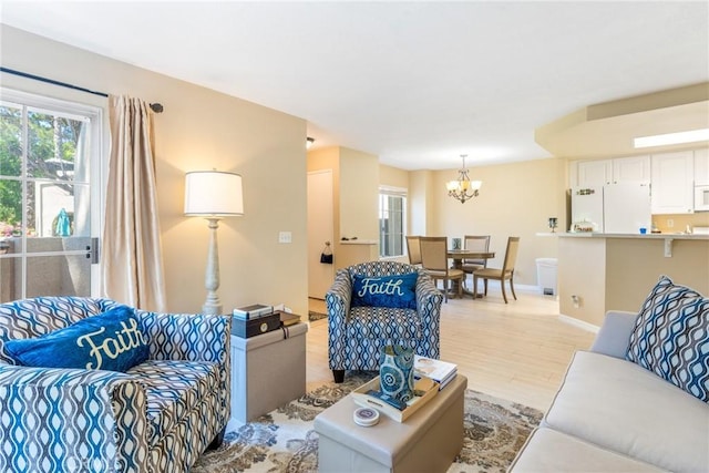 24352 Berrendo Unit 4, Aliso Viejo, CA 92656 - living room featuring a chandelier, light wood finished floors, plenty of natural light, and baseboards
