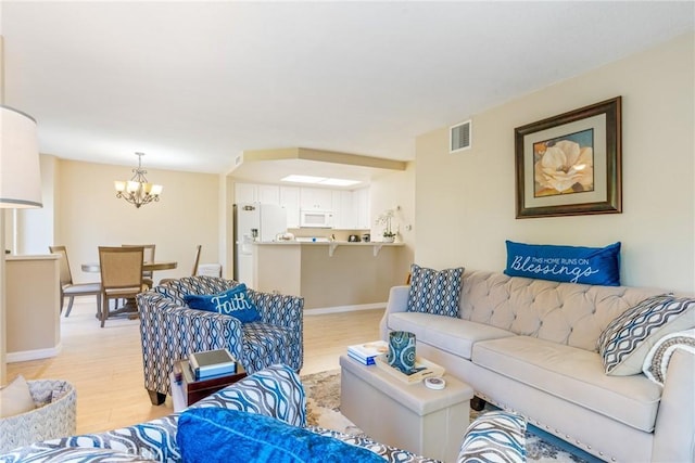 24352 Berrendo Unit 4, Aliso Viejo, CA 92656 - living area featuring a chandelier, light wood-style floors, and baseboards