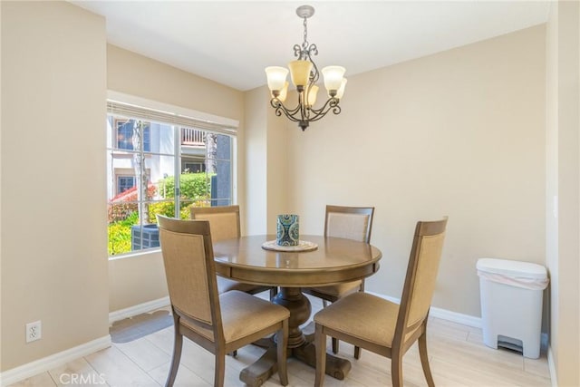 dining area with baseboards and a chandelier