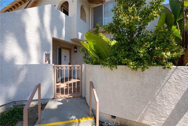 24352 Berrendo Unit 4, Aliso Viejo, CA 92656 - view of side of home with stucco siding, crawl space, and a gate