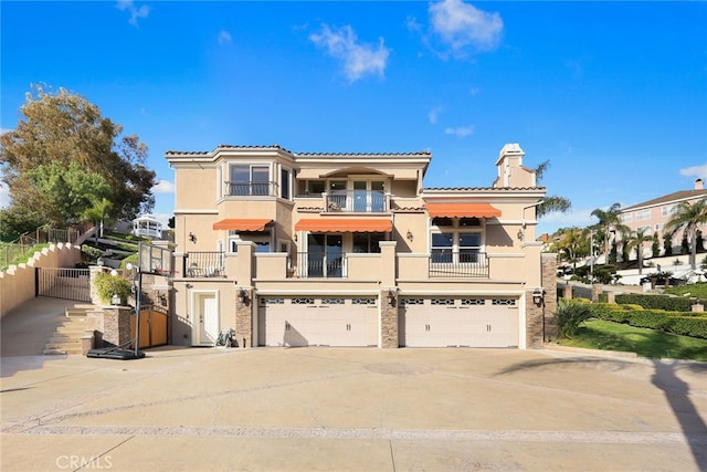 15841 Aurora Crest Dr, Whittier, CA 90605 - rear view of house featuring a balcony, stucco siding, a chimney, an attached garage, and a tile roof